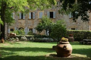 a large flower pot sitting in the grass in front of a building at Fattoria San Donato in San Gimignano