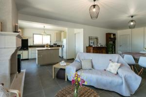 a living room with a blue couch and a kitchen at L'Instant Nouveau chambres d'hôtes in Carennac +11 photos