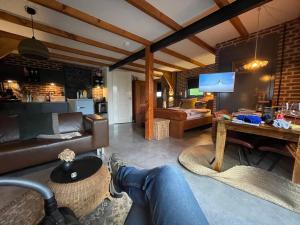 a living room with a person sitting on a couch at De Bommelerhoeve B&B & Vakantiewoning Dirkje in Poederoijen