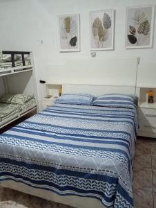 a bedroom with a blue and white striped bed at Maria Hostel Brasil gru in Guarulhos +4 photos