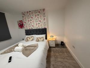 a bedroom with a white bed with two towels on it at Bpsairbnbltd in London