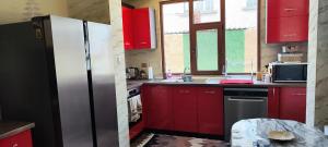 a kitchen with red cabinets and a stainless steel refrigerator at Спа къща Нико in Elkhovo