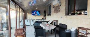 a patio with a table and chairs and a tv at Спа къща Нико in Elkhovo +18 photos
