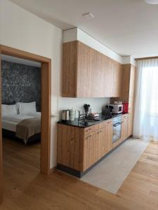eine Küche mit Holzschränken und ein Bett in einem Zimmer in der Unterkunft Gemmi Hotel & Spa in Kandersteg