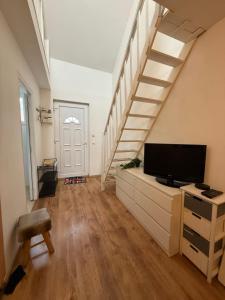 a living room with a tv and a staircase at Duplex proche aéroport CDG et Paris in Sarcelles