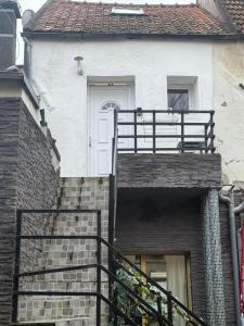 a white door on a brick building with a staircase at Duplex proche aéroport CDG et Paris in Sarcelles