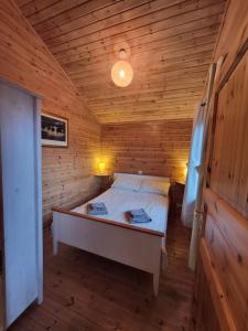 a bedroom with a bed in a wooden cabin at Eas Lodge in Tobermory