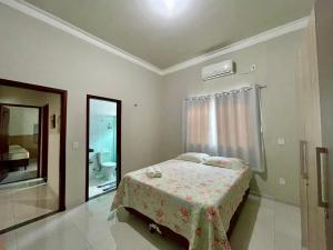 a bedroom with a bed and a bathroom with a window at Casa dos Ventos Barreirinhas in Barreirinhas