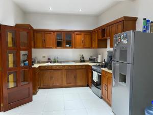 a kitchen with wooden cabinets and a stainless steel refrigerator at Modern colonial house in Apastepeque