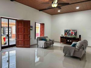 a living room with two chairs and a tv at Modern colonial house in Apastepeque