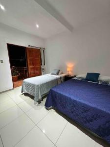 a bedroom with two beds and a window at Modern colonial house in Apastepeque