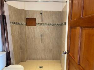 a bathroom with a shower with a toilet at Modern colonial house in Apastepeque +6 photos