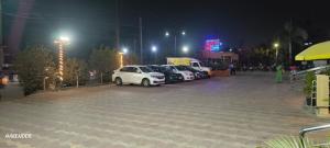 a group of cars parked in a parking lot at night at HOTEL SVM GRAND RAMANTHAPUR in Hyderabad