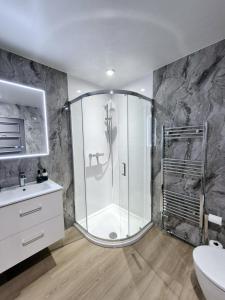 a bathroom with a shower and a sink at St Olaf Golf Hotel in Cruden Bay +54 photos