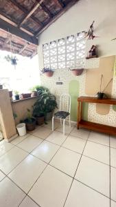 a room with a chair and a table and some plants at Descanso e aconchego in Aparecida