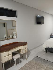 a bedroom with a dressing table and a mirror at Kinn Accommodation in Bloemfontein
