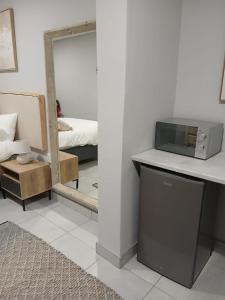 a room with a counter with a microwave and a mirror at Kinn Accommodation in Bloemfontein +4 photos