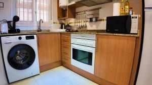 a kitchen with a washing machine and a washer at Apartalux Magic Silver in Oropesa del Mar +48 photos