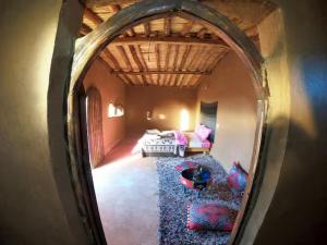 a reflection of a room with a bed and a mirror at Sahara Authentic Berber Camp in Mhamid