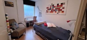 a bedroom with a bed and a chair and a desk at BlauweBoshuis in Koekange