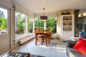 a dining room with a table and some windows at BlauweBoshuis in Koekange