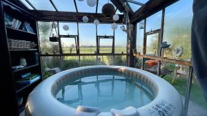 a large bath tub in a room with a window at De Bommelerhoeve B&B & Vakantiewoning Dirkje in Poederoijen