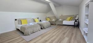 a room with three beds with yellow pillows at Le Patio de l'Isle 2nd Duplex in Périgueux
