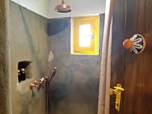 a bathroom with a shower and a window on the wall at Kostoulis Traditional House in Lefkes +7 photos