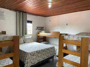 a room with three bunk beds and a table at Hostel mineiros in Aracaju