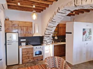 a kitchen with a white refrigerator and a staircase at Kostoulis Traditional House in Lefkes