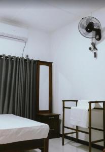 a room with two beds and a window with a fan at Meegas Sewana Resort in Minneriya
