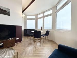 ein Wohnzimmer mit Tisch, Stühlen und Fenstern in der Unterkunft Glamour Point in Reda