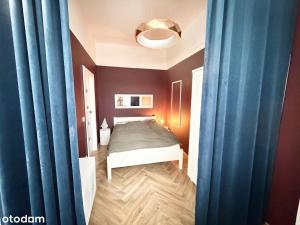 ein kleines Schlafzimmer mit einem Bett und blauen Vorhängen in der Unterkunft Glamour Point in Reda