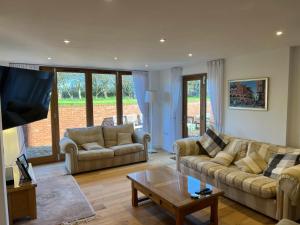 a living room with two couches and a coffee table at Glebe Barn in Cuxham