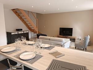 a dining room with a table with wine glasses on it at Gite les trois Petiots in Pirou