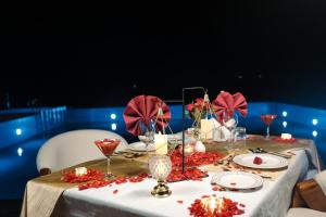 a table with red flowers and glasses on it at Astralis Resort Coorg in Madikeri +59 photos