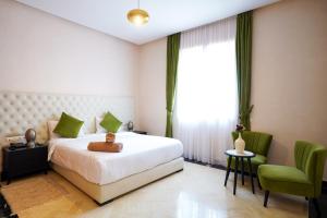 a bedroom with a bed with a teddy bear on it at Palais Dar Souhir in Aït Bou Zguia +12 photos