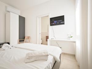 a white room with a bed with a tv on the wall at Estelle in Bari +132 photos