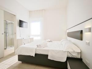 a white bedroom with a bed with towels on it at Estelle in Bari