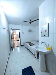 a white bathroom with a sink and a bed at Kulswami Cottage Alibag in Alibaug +106 photos