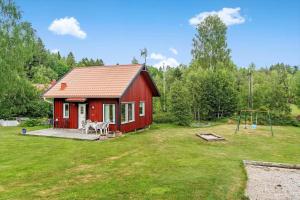 a red house with a playground and a swing at BOH425-Henan-Tryckhalan-140 in Henån