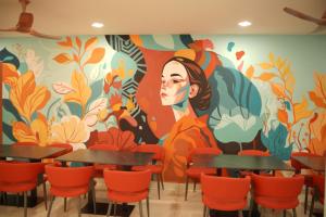 a mural in a restaurant with tables and chairs at Hotel Flamount Hitech City in Hyderabad
