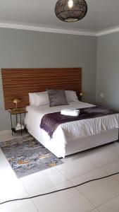 a bedroom with a large bed with a wooden headboard at The Botik Hides in Mogwase