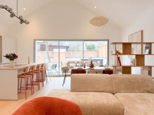a living room with a couch and a kitchen with a bar at Maison Nova in Talant