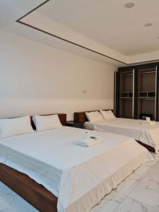 two beds in a hotel room with two bedsvisor at Koregon Hotel in Fort Stotsenburg