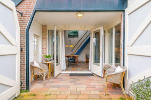 an open door to a patio with chairs and a table at de Dars in Callantsoog