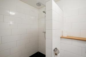 a white tiled shower with a toilet in a bathroom at de Dars in Callantsoog +36 photos