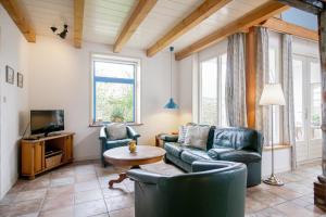 a living room with two couches and a tv at de Dars in Callantsoog
