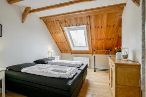 a bedroom with a bed and a wooden ceiling at de Dars in Callantsoog