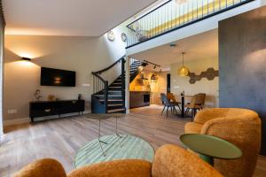 a living room with a staircase and a dining room at Schoapdiek Huuskes in Overdinkel